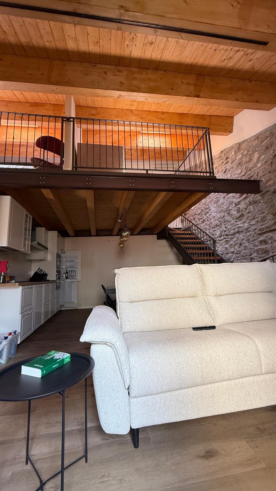 Zona giorno e travi lignee dopo l'intervento